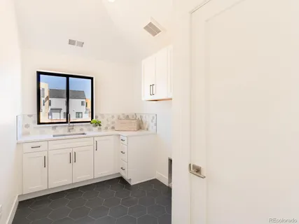 a bathroom with a granite countertop sink and a window