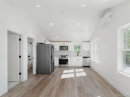 a view of kitchen with refrigerator a window and cabinets