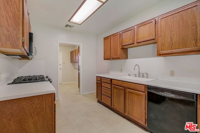 a kitchen with stainless steel appliances a sink stove and cabinets