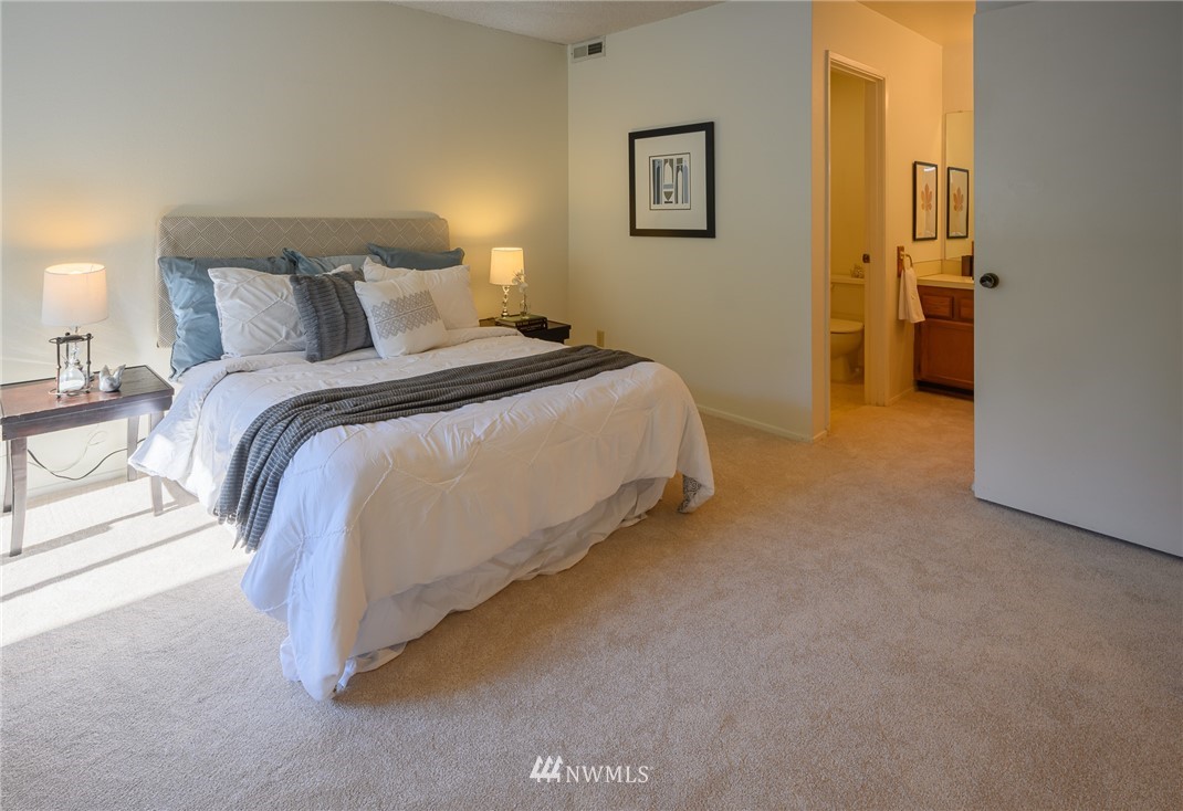 7335 Old Redmond Road, Unit 125 Redmond, WA 98052 - Photo 11 of 15 a spacious bedroom with a bed and a lamp