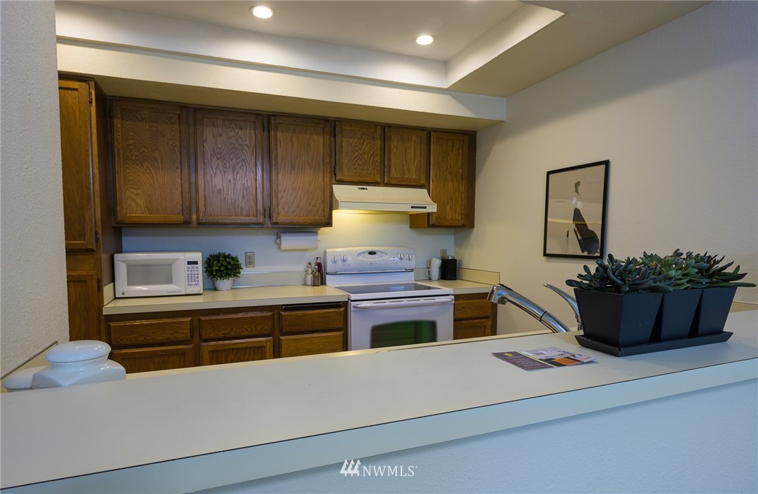 7335 Old Redmond Road, Unit 125 Redmond, WA 98052 - Photo 8 of 15 a kitchen with stainless steel appliances granite countertop a stove and a refrigerator