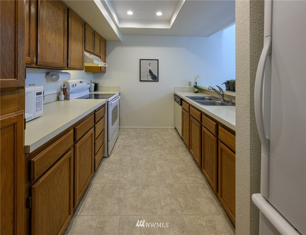 7335 Old Redmond Road, Unit 125 Redmond, WA 98052 - Photo 9 of 15 a kitchen with stainless steel appliances granite countertop a stove a sink and a refrigerator
