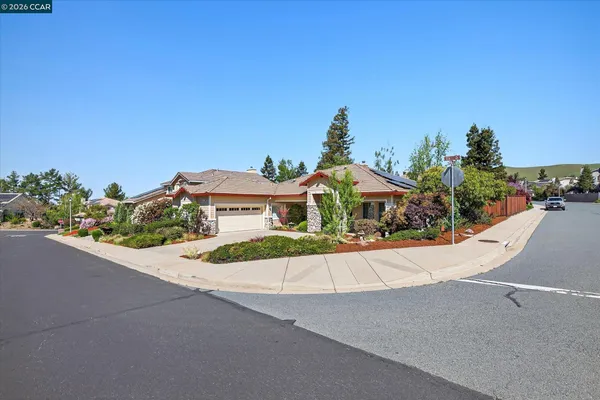 a view of a house with a street and a yard