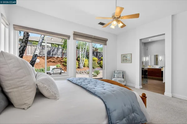 a bedroom with a bed and glass walk in closet