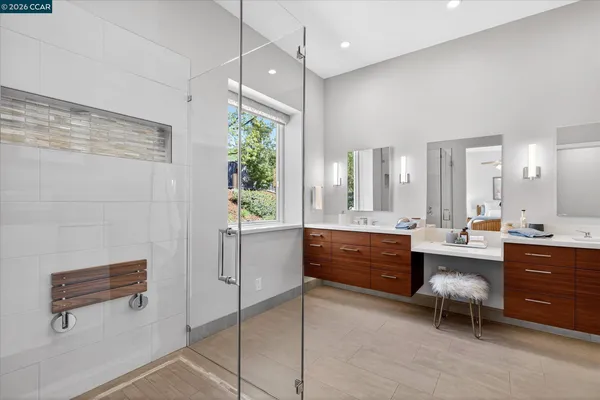 a large bathroom with a tub a double vanity sink a potted plant and a shower