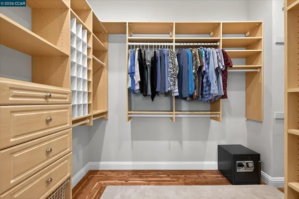 a view of walk in closet with clothes and shoes