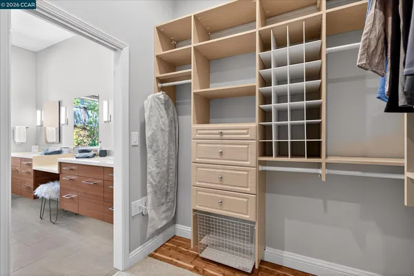 a view of walk in closet with clothes and shoes