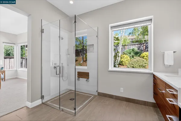 a bathroom with a glass shower door and a window