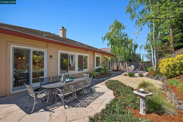 a view of a house with backyard sitting area and garden