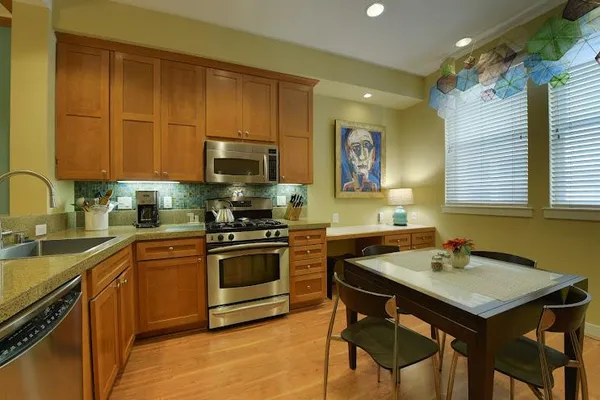 a kitchen with stainless steel appliances granite countertop a stove a sink dishwasher and a microwave oven with cabinets