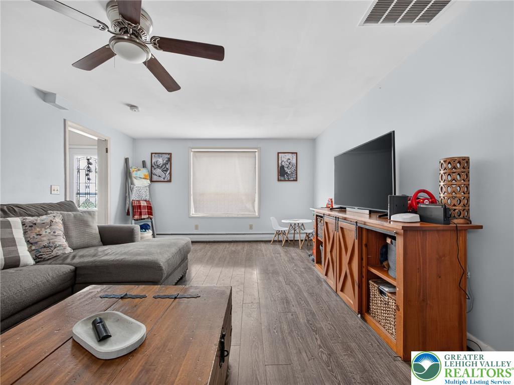 2628 Levans Road Coplay, PA 18037 - Photo 11 of 54 Natural light illuminates the rich hardwood-style flooring in this versatile living space.