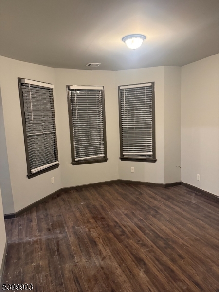 663 South 15th Street Newark, NJ 07103 - Photo 2 of 4 an empty room with wooden floor and windows