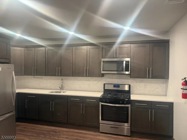 a kitchen with granite countertop a sink and steel appliances