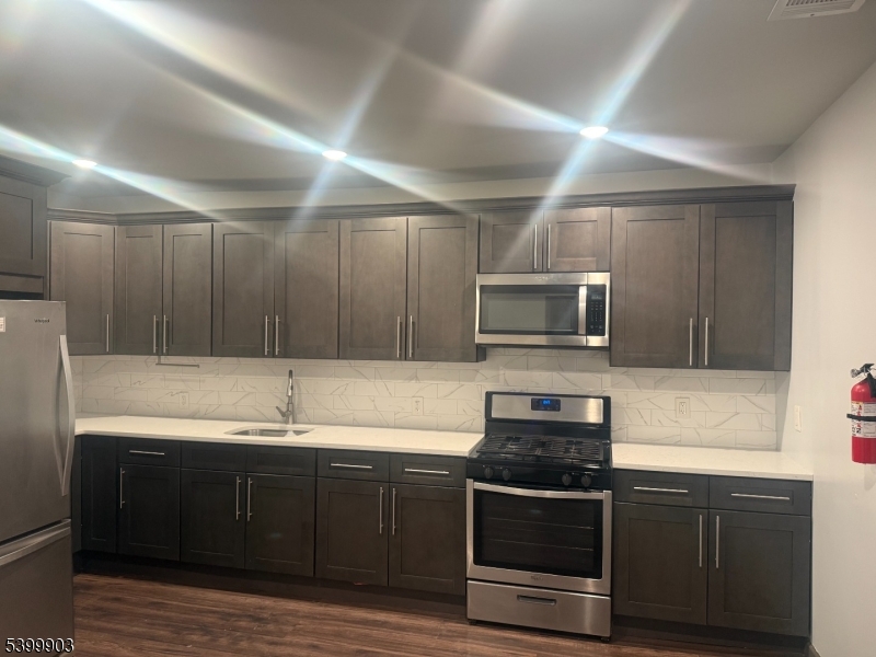 663 South 15th Street Newark, NJ 07103 - Photo 3 of 4 a kitchen with granite countertop a sink and steel appliances