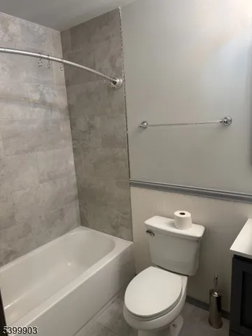 a white toilet and tub sitting next to a bathroom sink