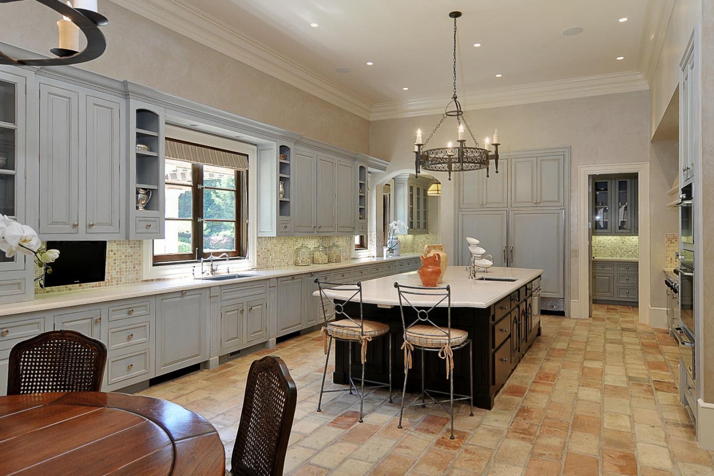 1 Faxon Road Atherton, CA 94027 - Photo 11 of 19 a large kitchen with kitchen island a dining table chairs and a chandelier