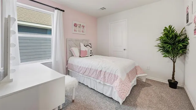 a bedroom with a bed and a potted plant
