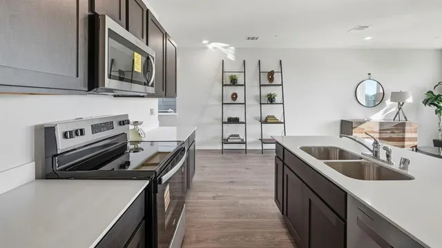a kitchen with stainless steel appliances a stove sink microwave and cabinets