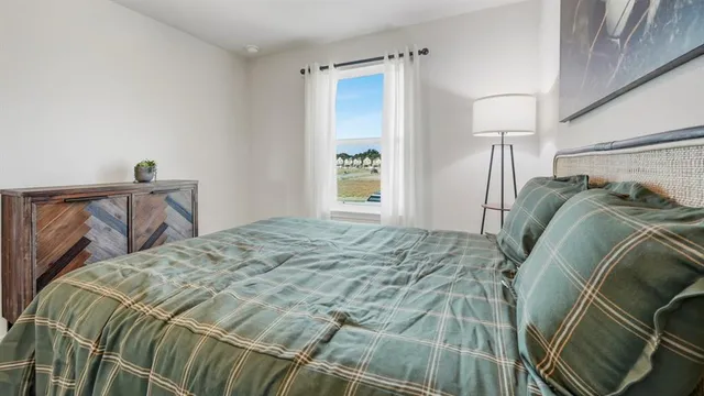 a bed sitting in a bedroom next to a window