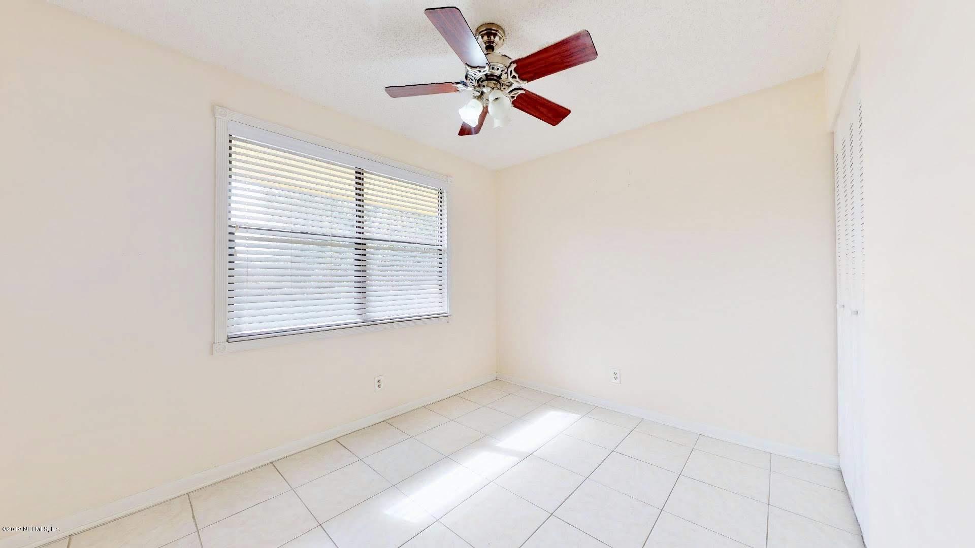 650 Pope Road, Unit 217 St. Augustine, FL 32080 - Photo 16 of 25 an empty room with chandelier fan and windows