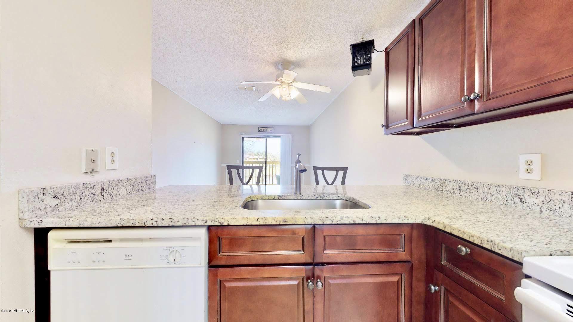 650 Pope Road, Unit 217 St. Augustine, FL 32080 - Photo 8 of 25 a kitchen with cabinets and chandelier