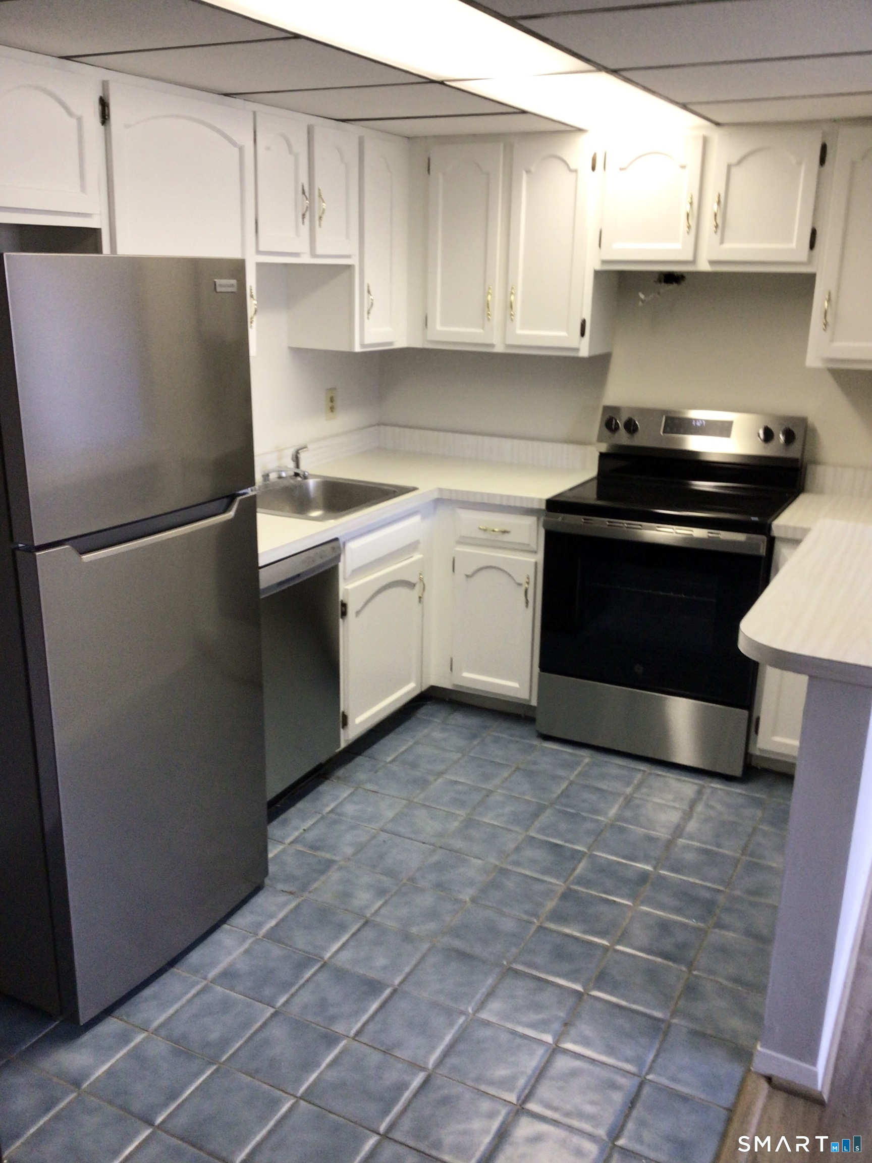 330 Short Beach Road, Unit G12 East Haven, CT 06512 - Photo 7 of 22 a kitchen with a sink and a refrigerator