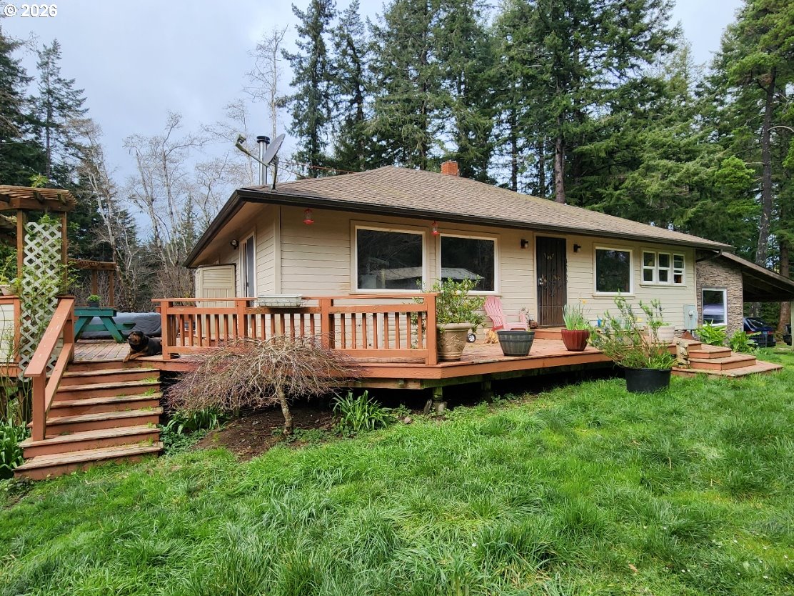 45366 Highway 101 Sixes, OR 97476 - Photo 1 of 34 a view of a house with a yard and deck