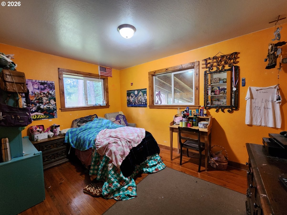 45366 Highway 101 Sixes, OR 97476 - Photo 11 of 34 a bed room with a bed and dresser