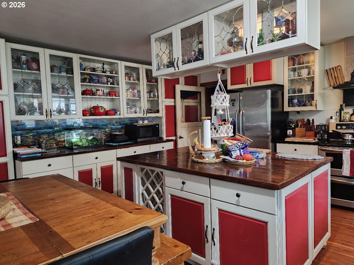 45366 Highway 101 Sixes, OR 97476 - Photo 17 of 34 a kitchen filled with stainless steel appliances kitchen island granite countertop a dining table and chairs