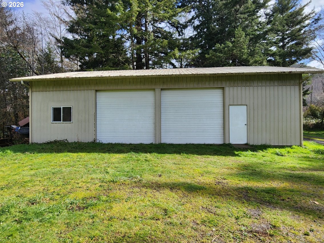 45366 Highway 101 Sixes, OR 97476 - Photo 2 of 34 a backyard of a house with lots of green space