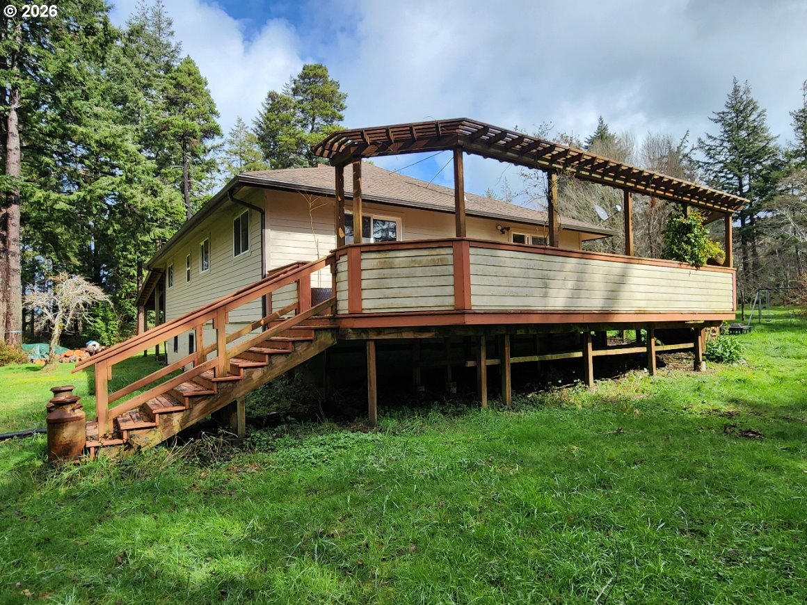 45366 Highway 101 Sixes, OR 97476 - Photo 23 of 34 a view of a house with a yard and a wooden deck