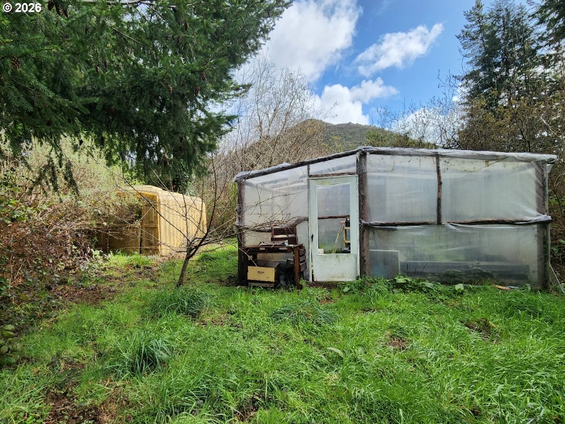 45366 Highway 101 Sixes, OR 97476 - Photo 28 of 34 a backyard of a house with table and chairs