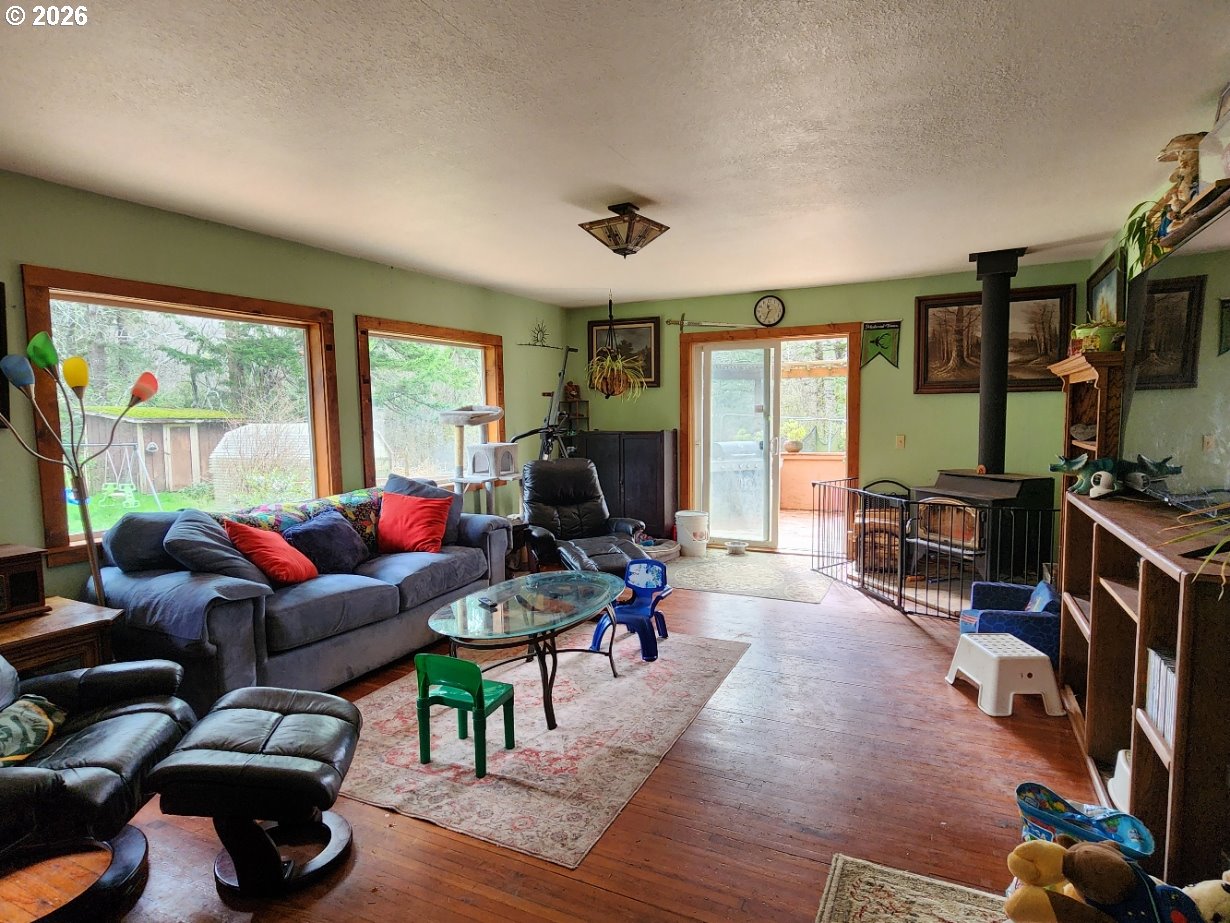 45366 Highway 101 Sixes, OR 97476 - Photo 7 of 34 a living room with furniture a flat screen tv and a large window