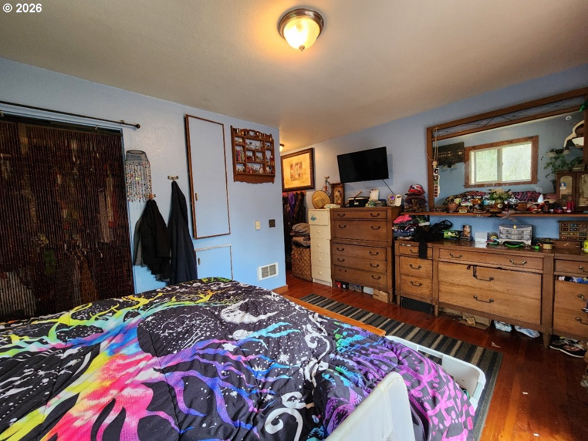 45366 Highway 101 Sixes, OR 97476 - Photo 9 of 34 a bedroom with a bed and a flat screen tv