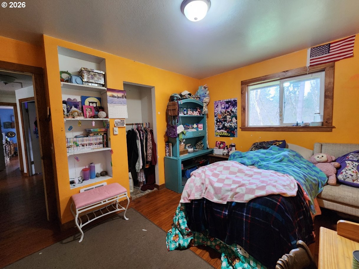 45366 Highway 101 Sixes, OR 97476 - Photo 10 of 34 a bedroom with a bed a dresser and book shelf