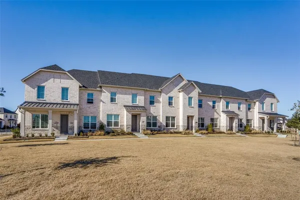 a front view of a residential apartment building with a yard