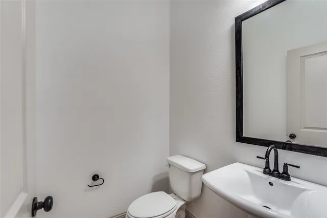 a bathroom with a sink mirror and toilet
