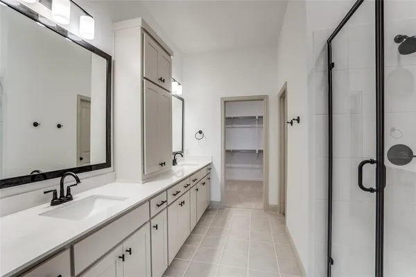 a bathroom with double vanity sinks and a mirror