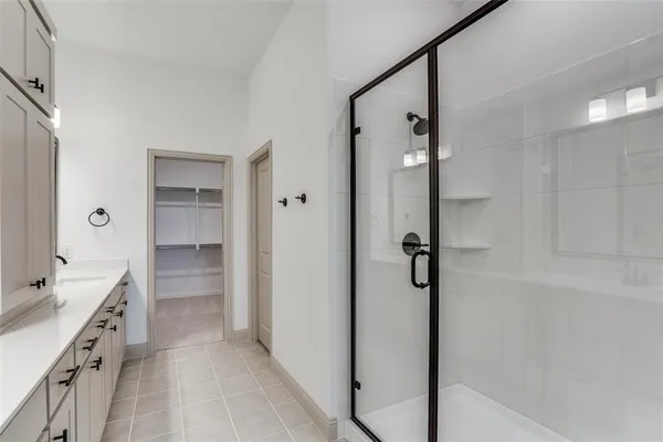 a bathroom with a double vanity sink a toilet a mirror and shower