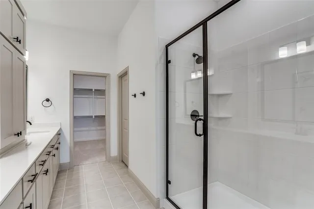 a bathroom with a double vanity sink a toilet a mirror and shower