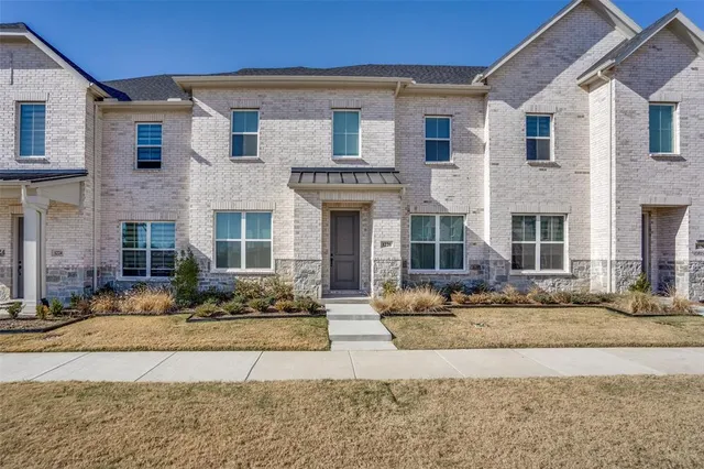 a front view of a brick house with a yard