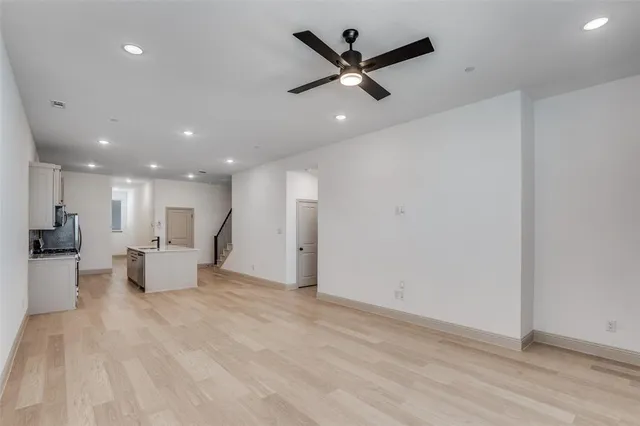 a view of a big room with chandelier fan and windows