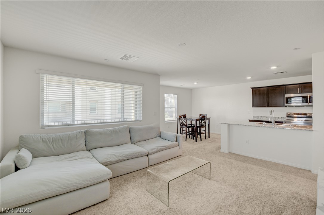 6924 Spicy Merlot Street North Las Vegas, NV 89086 - Photo 83 of 83 An open floorplan seamlessly connects the living area, dining nook, and a modern kitchen.