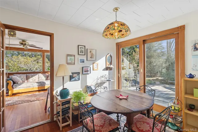 a view of a dining room with furniture large windows and wooden floor