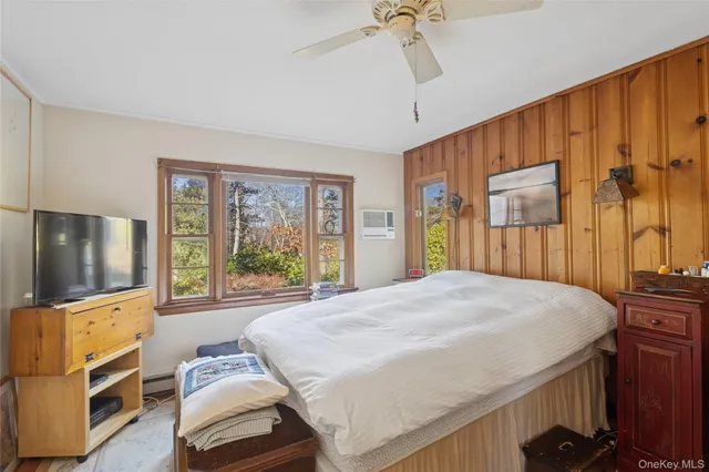 a bedroom with a bed and a flat tv screen on dresser