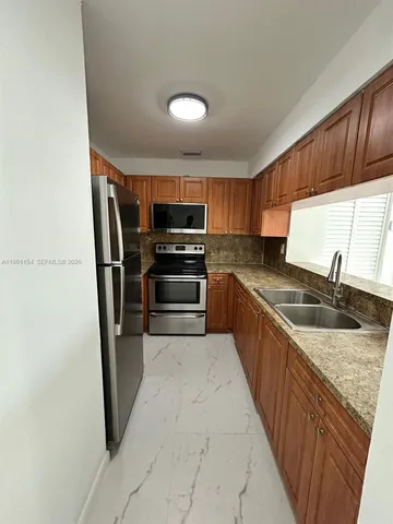 a large kitchen with a sink and stainless steel appliances