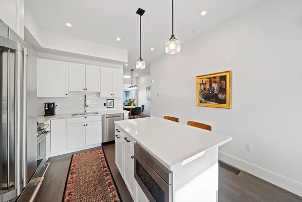 a kitchen that has a lot of cabinets in it and wooden floors
