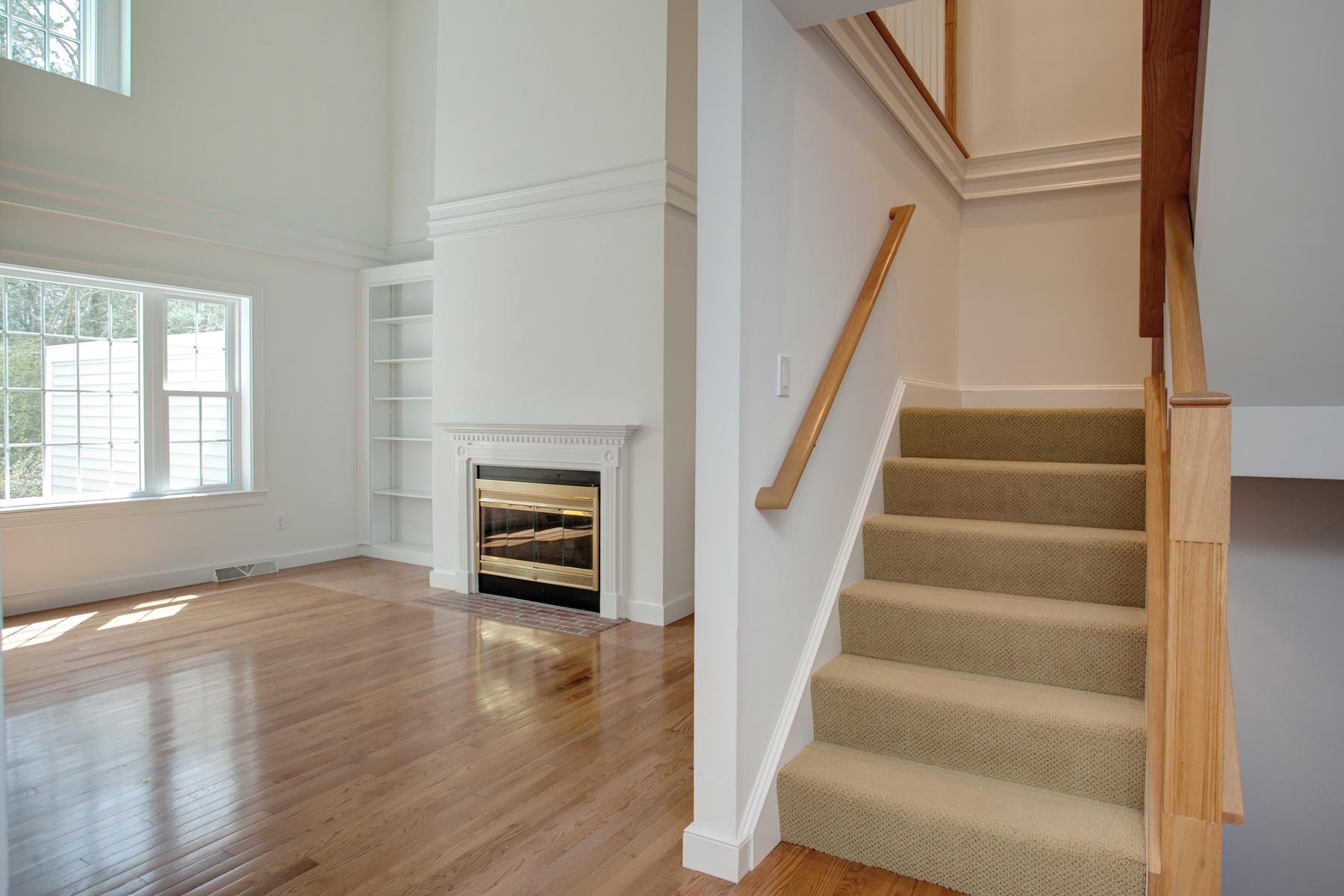 15 Hampton Court, Unit 15 Mashpee, MA 02649 - Photo 8 of 33 a view of an empty room with wooden floor and stairs
