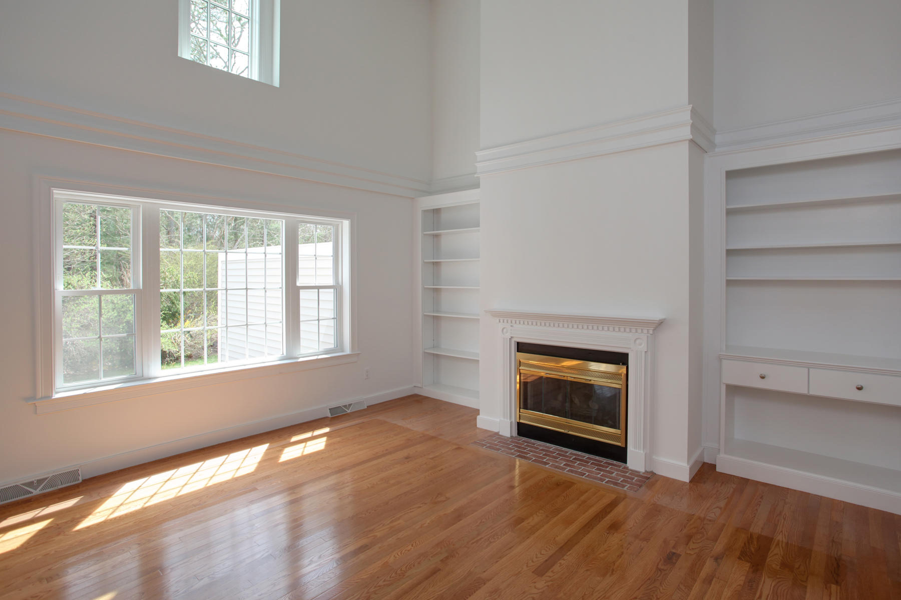 15 Hampton Court, Unit 15 Mashpee, MA 02649 - Photo 9 of 33 an empty room with windows and fireplace