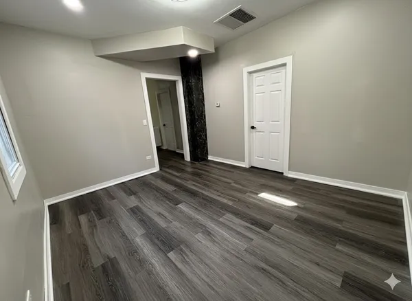 an empty room with wooden floor and closet